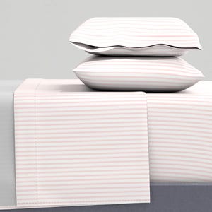 May include: A white and pink striped bed sheet set with two pillowcases. The sheet set is made of soft, comfortable fabric and is perfect for adding a touch of colour to your bedroom.