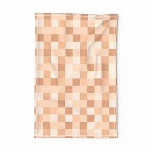 Op de afbeelding: Een beige en witte geruite keukendoek met een subtiel patroon. De handdoek is gemaakt van een zachte, absorberende stof en is perfect voor het drogen van afwas, handen en morsen.