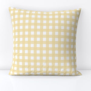 May include: A yellow and white gingham pillow with a square pattern.