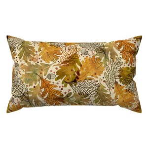 May include: A rectangular throw pillow with a cream-colored background and a pattern of brown, yellow, and green oak leaves and acorns.