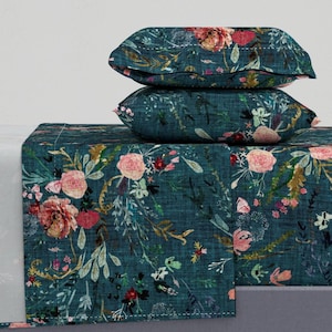 May include: A teal blue bedding set with a floral pattern featuring pink, red, and yellow flowers. The set includes a flat sheet, fitted sheet, and two pillowcases.