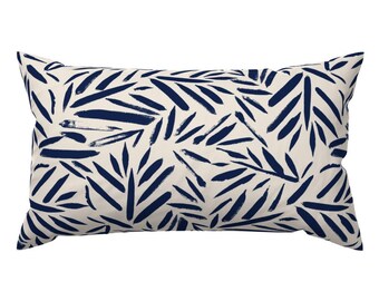 May include: A rectangular throw pillow with a white background and a navy blue leaf pattern. The leaves are painted in a brushstroke style.