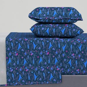 May include: A blue and pink bedding set with a whale and sea life pattern. The set includes a flat sheet, fitted sheet, and two pillowcases.