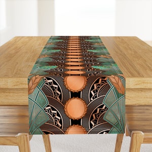 May include: A teal and copper table runner with a geometric pattern. The pattern features circles, squares, and triangles. The runner is perfect for adding a touch of elegance to any table.