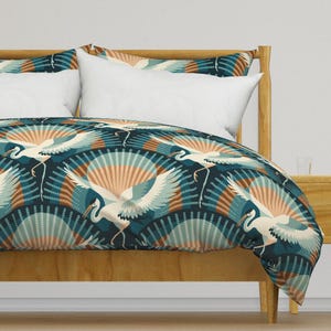 May include: A teal blue duvet cover with a repeating pattern of white cranes flying in front of a teal blue and brown fan design.