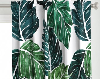 May include: White curtains with a green and blue tropical leaf pattern. The leaves are stylized and resemble monstera leaves.