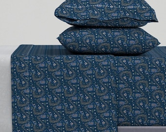 May include: A blue and gold patterned fitted sheet and two matching pillowcases. The sheet features a floral design with small white flowers and gold accents.