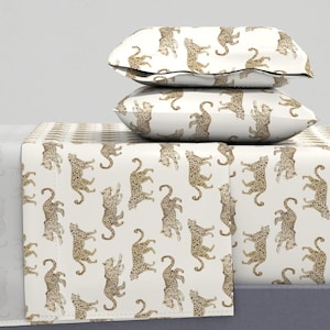 May include: A white bedding set with a leopard print pattern. The set includes a fitted sheet, flat sheet, and two pillowcases.