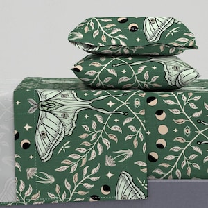 May include: Green bedding set with a whimsical pattern of moths, leaves, and crescent moons. The set includes a flat sheet, fitted sheet, and two pillowcases.