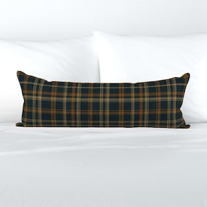 May include: A long, rectangular lumbar pillow featuring a dark navy blue, brown, and tan plaid pattern. The fabric has a woven texture with intersecting horizontal and vertical lines forming a classic grid design across the entire surface.
