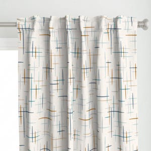 May include: A white curtain panel featuring a repeating pattern of thin, intersecting horizontal and vertical lines in shades of dark blue, light blue, and mustard yellow. The fabric hangs from a silver metal rod with pleated top headers.