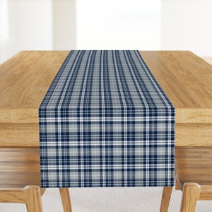 May include: A blue and white checked table runner. The runner is on a wooden table.
