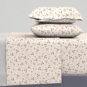 May include: A white bedding set with a brown and white floral pattern. The set includes a fitted sheet, flat sheet, and two pillowcases.