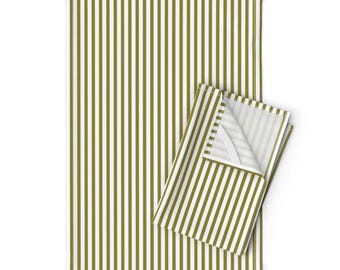 Puede incluir: Una servilleta de tela doblada y un mantel rectangular a juego. Ambos artículos presentan un patrón de rayas verticales en verde oliva y blanco. El mantel está desplegado, mientras que la servilleta está doblada.