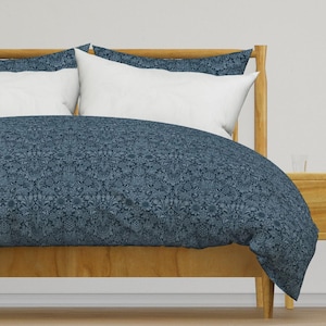 May include: A blue floral patterned duvet cover with white accents on a wooden bed frame. The duvet cover is made of soft, comfortable fabric and features a repeating floral design.
