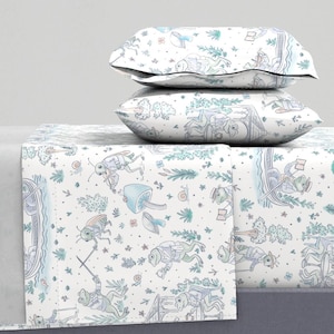 Könnte beinhalten: Weißes Bettwäsche-Set mit einem skurrilen Druck mit Insekten, Fröschen, Pilzen und anderen Waldelementen in Blau- und Grüntönen. Das Set enthält zwei Kissenbezüge und ein Spannbetttuch.