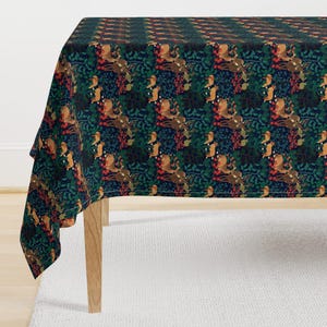 May include: A dark blue tablecloth with a repeating pattern of stylized deer, birds, and berries. The pattern is in shades of red, green, brown, and white.