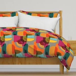 Könnte beinhalten: Ein Bettbezug mit einem geometrischen Muster aus überlappenden Kreisen in Orange-, Gelb-, Türkis-, Rosa- und Brauntönen auf grauem Hintergrund.