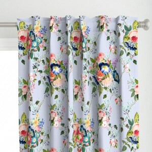 May include: A pair of light blue curtains with a floral pattern featuring pink, red, blue, and yellow flowers. The floral pattern is repeated throughout the fabric.