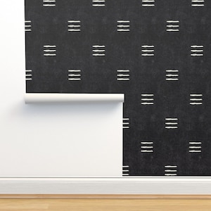 Puede incluir: Papel tapiz negro y blanco con un patrón repetitivo de líneas horizontales. El papel tapiz está enrollado y parcialmente desenrollado, mostrando el patrón.