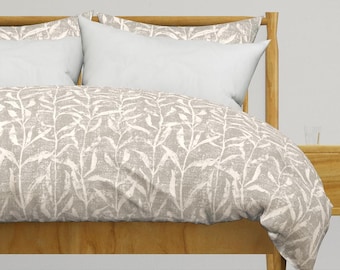 May include: A beige duvet cover with a white leaf pattern on a wooden bed frame. The duvet cover is made of soft, breathable fabric and is perfect for any bedroom.