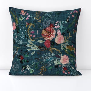 May include: Teal blue throw pillow with a floral pattern featuring pink, red, and white flowers and green leaves.