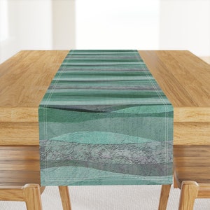 May include: A teal and gray striped table runner with a wavy pattern. The runner has a textured, almost woven look.