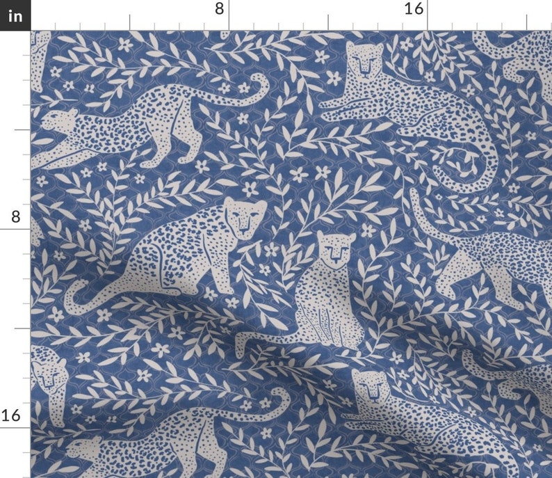 May include: A seamless pattern featuring white leopards and leafy branches on a blue background. The pattern is perfect for fabric, wallpaper, or wrapping paper.