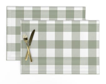 May include: Two sage green and white checkered placemats. The placemats are made of a woven fabric and have a subtle sheen.
