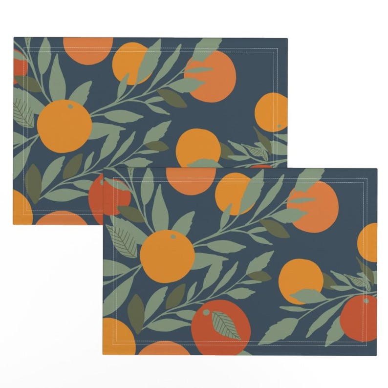 May include: Two blue placemats with a repeating pattern of orange fruit and green leaves.