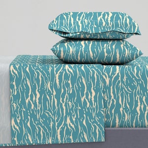 May include: A teal bed set featuring a cream-coloured, vertical, abstract pattern. The set includes a fitted sheet, a flat sheet, and two pillowcases. The sheets and pillowcases are made of a soft, comfortable material.