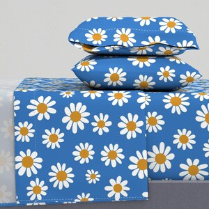 Puede incluir: Un juego de cama azul y blanco con estampado de margaritas con dos fundas de almohada a juego. La ropa de cama está hecha de tela suave y cómoda y presenta un diseño alegre y brillante.