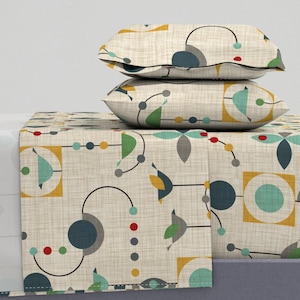 May include: A beige, cream, and green patterned bedding set with a geometric design. The set includes a flat sheet, fitted sheet, and two pillowcases.