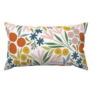 May include: A rectangular pillow with a white background and a floral pattern in shades of orange, yellow, pink, green, and blue.