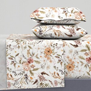 May include: A white bedding set with a floral pattern featuring brown, orange, and pink flowers and leaves. The set includes a fitted sheet, flat sheet, and two pillowcases.