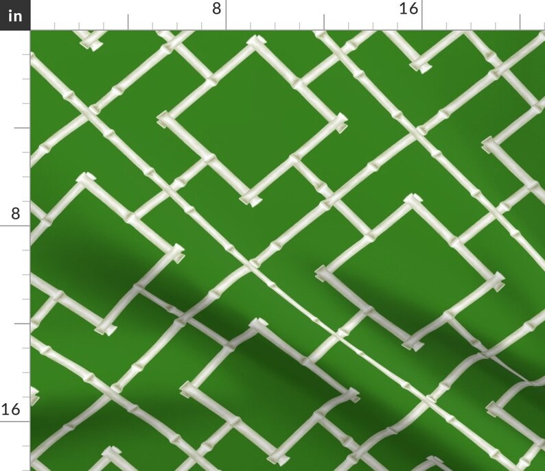 Pu&ograve; includere: Un tessuto verde con un motivo a traliccio di bamb&ugrave; bianco. Il motivo &egrave; un disegno geometrico ripetitivo di linee bianche sovrapposte.