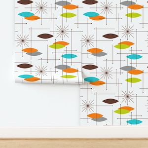 May include: Wallpaper featuring a white background with a repeating pattern of brown, orange, lime green, and turquoise leaf-shaped motifs interspersed with thin brown lines and dark brown starburst shapes arranged in a grid-like formation.