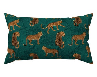 May include: A teal blue pillow with a repeating pattern of leopards on a dark green background. The leopards are in a variety of poses, including walking, sitting, and lying down.