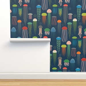May include: A dark blue wallpaper with a repeating pattern of colorful jellyfish. The jellyfish are various sizes and shapes, with different colored bells and tentacles.