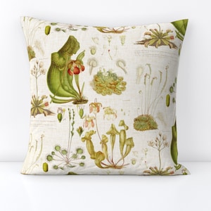 Peut inclure: Coussin carré avec une impression botanique présentant des illustrations détaillées de diverses plantes carnivores dans des tons de vert, de jaune et de rouge sur un fond crème. Le coussin a une texture semblable à celle du lin.