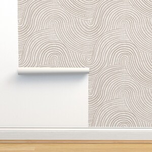 May include: A roll of wallpaper with a white background and a pattern of brown, curved lines that resemble a mosaic.