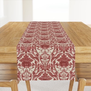 Może przedstawiać: Czerwono-biały bieżnik stołowy z kwiatowym wzorem. Bieżnik wykonany jest z tkaniny przypominającej len i ma subtelny połysk.