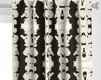 May include: Black and white patterned curtains with a repeating abstract design. The curtains have a subtle sheen and a soft, flowing texture.
