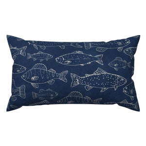 May include: A navy blue cushion featuring a white outline of various fish designs. The cushion is rectangular in shape and has a soft, plush texture.
