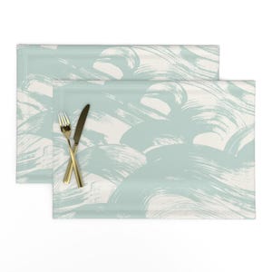 Puede incluir: Un juego de tres tazas de cerámica con un acabado mate moteado. Cada taza presenta un color diferente: azul claro, crema y gris. Las tazas tienen un diseño simple y moderno y un asa cómoda.