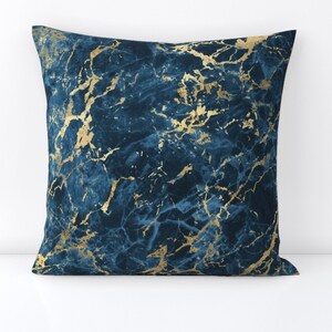 May include: A blue and gold throw pillow with a marble pattern.