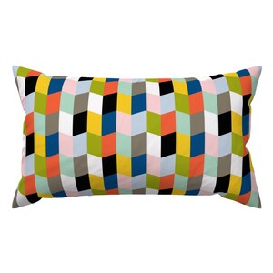 May include: A rectangular pillow with a geometric pattern in shades of green, blue, yellow, pink, orange, white, and black.