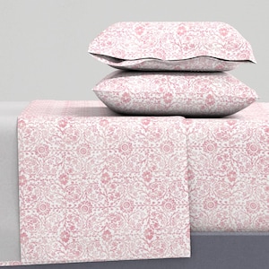 May include: A pink and white floral patterned bed sheet set with two pillowcases. The sheet set features a delicate floral design with a watercolor effect.