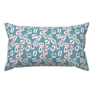 May include: A rectangular throw pillow featuring a repeating pattern of white Mahjong tiles scattered across a teal blue background. The tiles display various colorful symbols, Chinese characters, and the word Joker in red, green, and black ink.