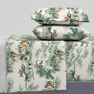 May include: A white and green patterned bed sheet with a repeating design of horses and riders in a woodland setting. Two matching pillowcases are stacked on top of the sheet.